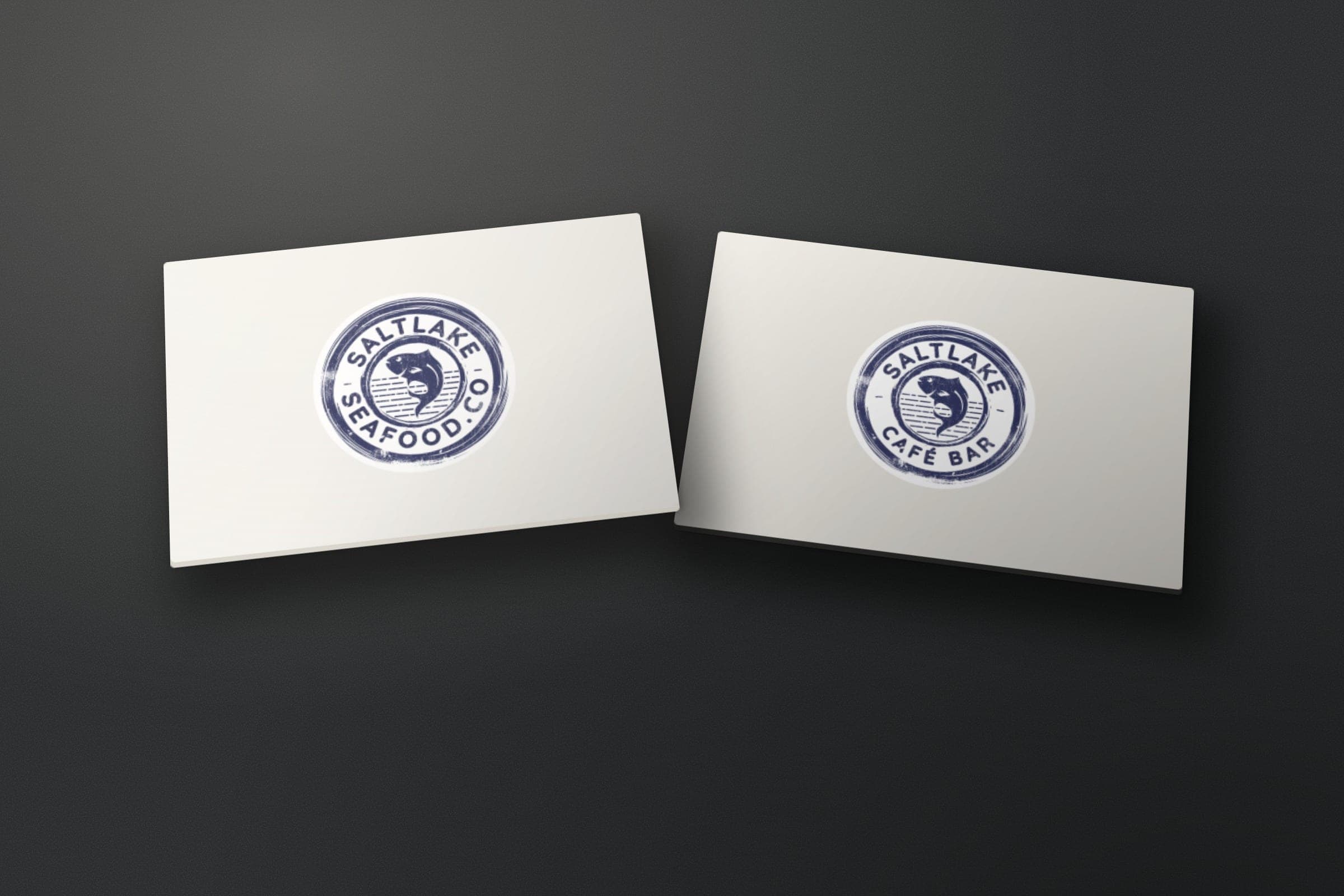 Mockup: the Saltlake Seafood Co. stamp logo and its Café Bar version on two cards.