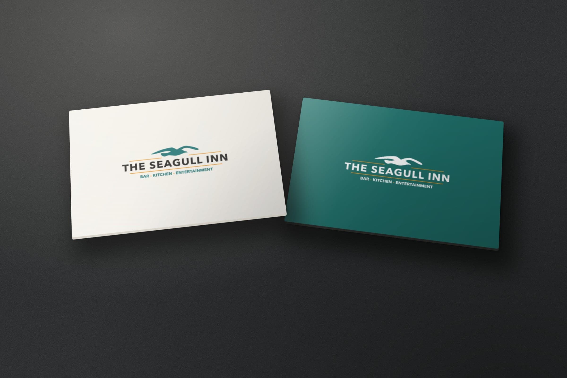 Mockup: The Seagull Inn logo on two cards, in colour on light and in white on teal.